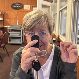 Woman holds smartphone close to her face and gestures with her other hand in a diner. 
